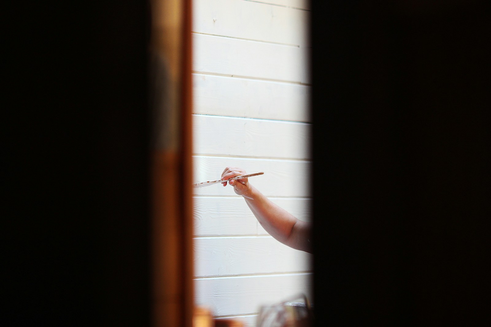 Application de peinture au rouleau sur un panneau de porte intérieure.