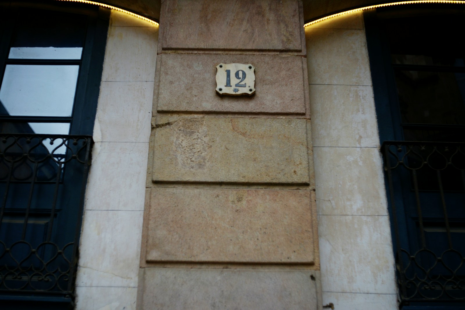 Applique murale d'extérieur fixée sur la façade en pierre d'une maison.