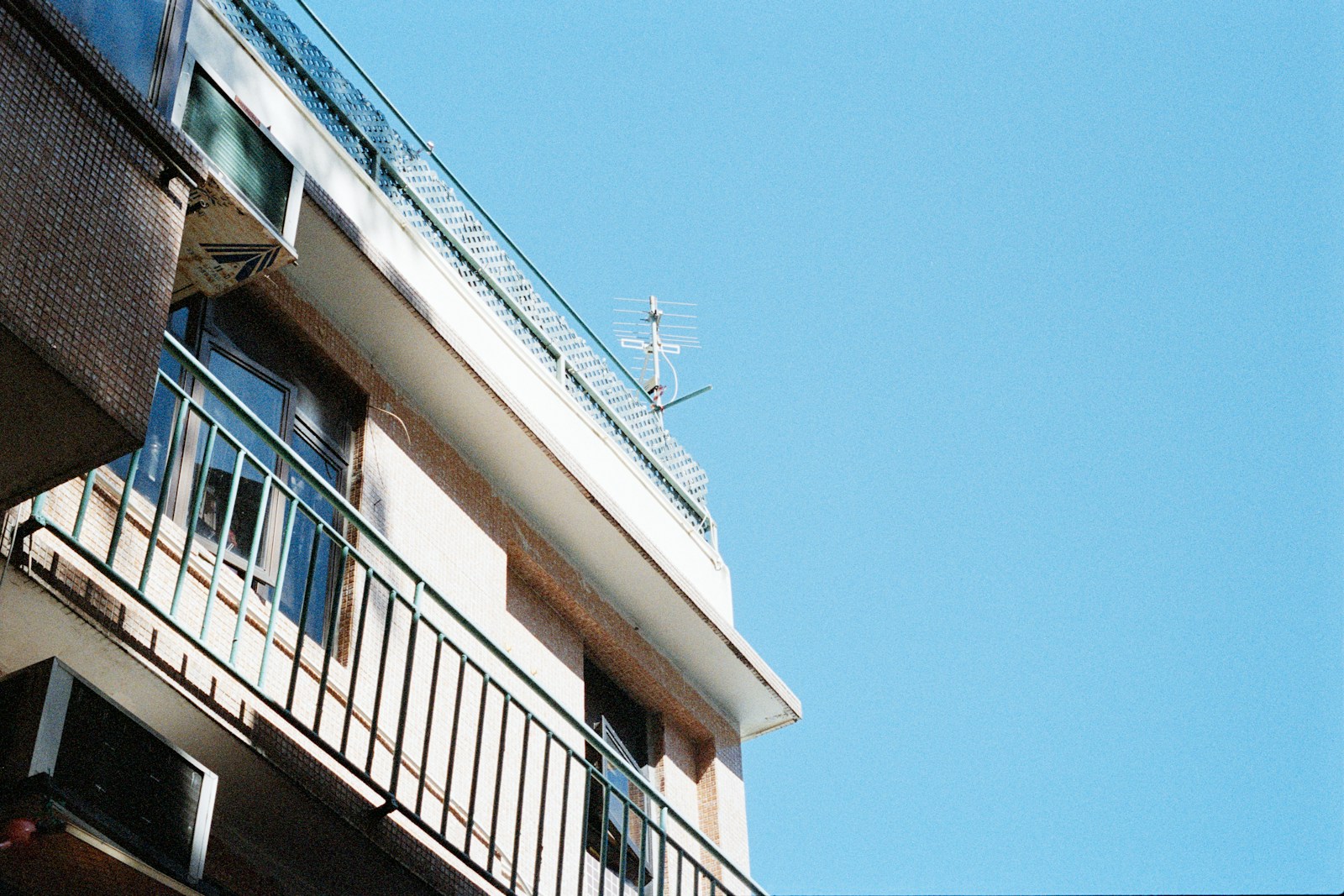 Balcon en saillie fermé par un garde-corps métallique sur la façade d'un immeuble.