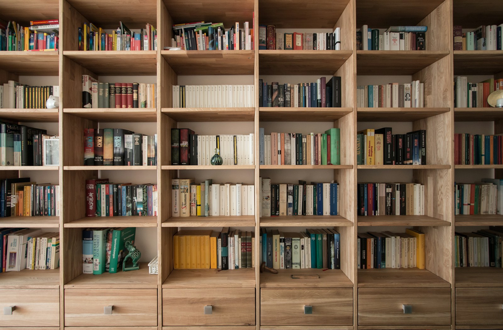 Bibliothèque en bois garnie de livres installée contre un mur.