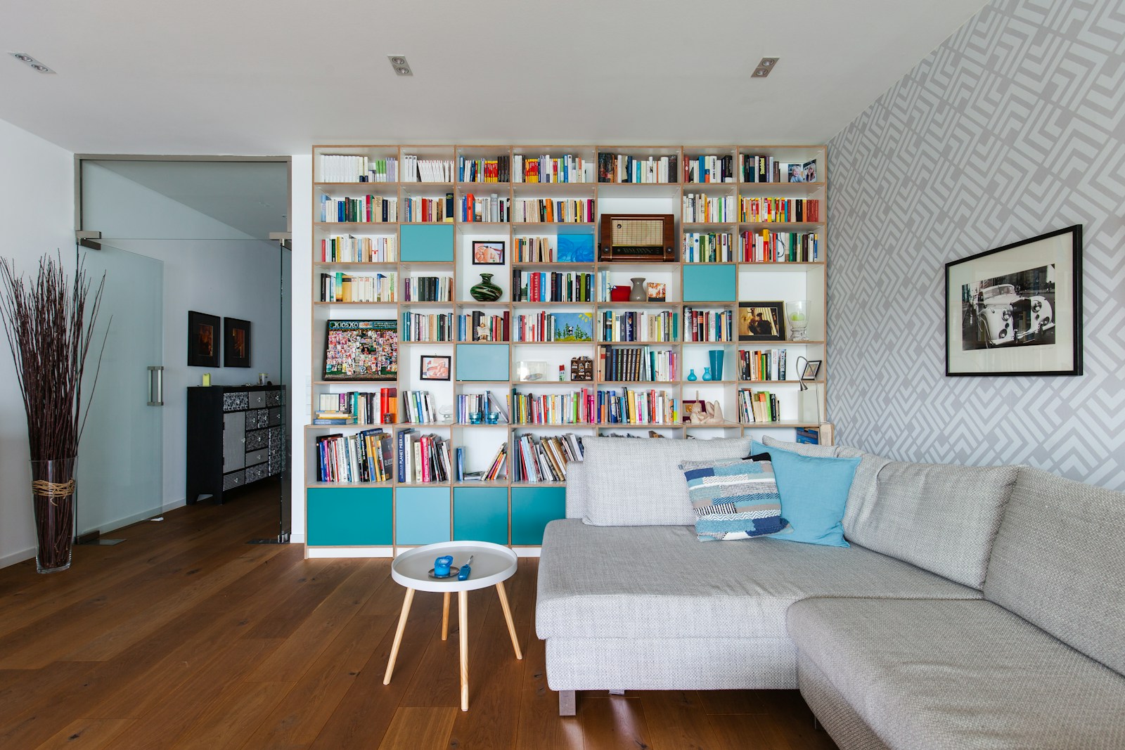 Bibliothèque toute hauteur dans un salon, rideaux montés près du plafond.