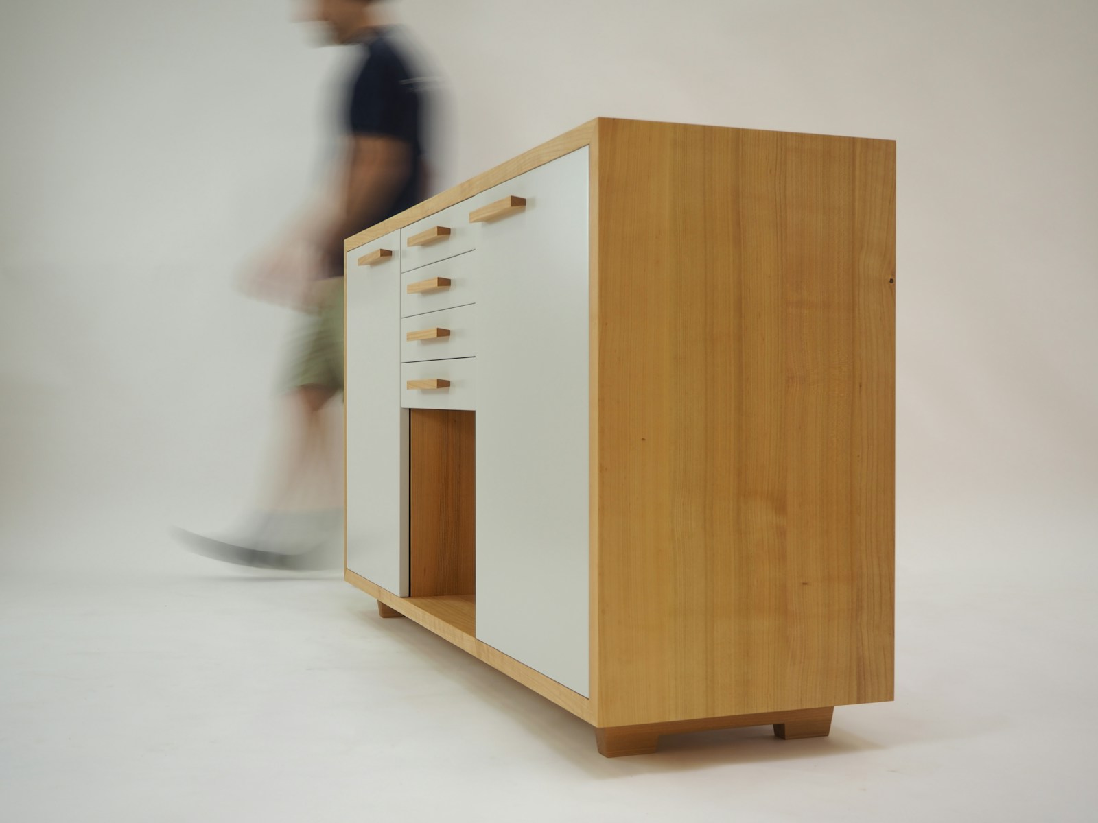 Buffet bas en bois posé en biais dans l'angle d'un salon.