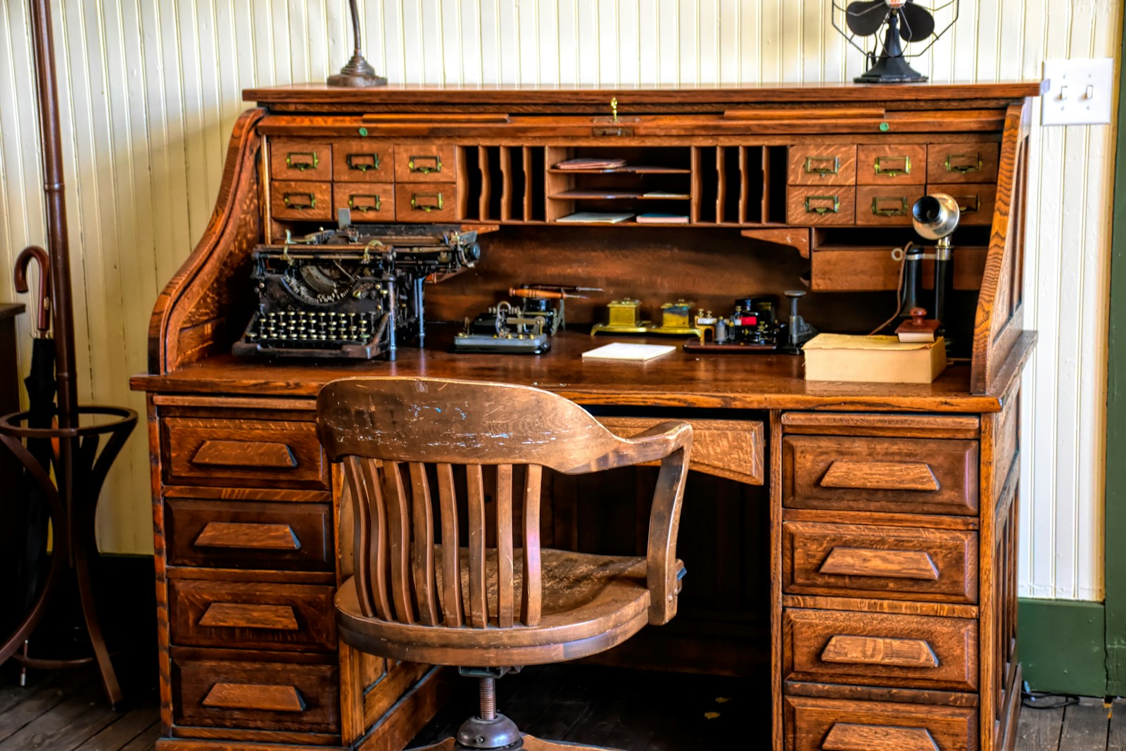 Bureau en bois ancien chiné, patine visible, dans une pièce lumineuse.