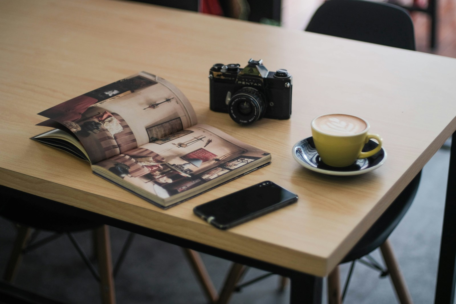 Carnet de notes et catalogue de mobilier posés sur une table