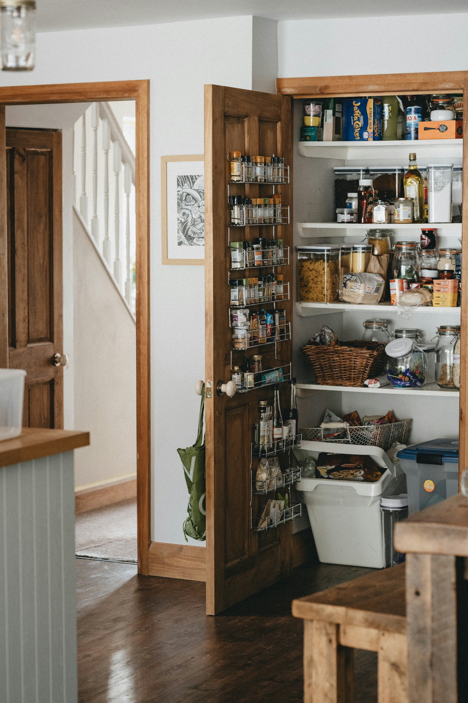 Cellier aménagé mêlant réserve alimentaire et espace buanderie, avec étagères en bois.