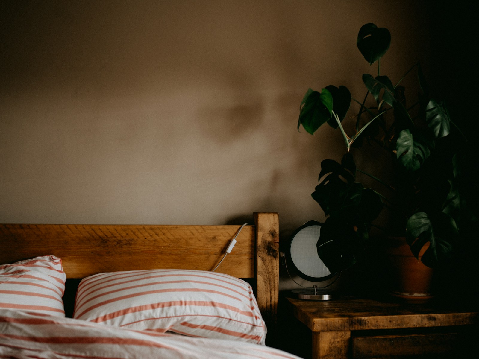 Chambre apaisée, tête de lit en bois adossée au mur et linge de lit en lin.