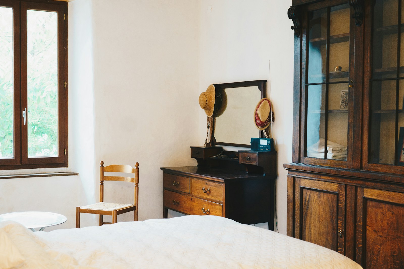 Chambre d'esprit maison de campagne française avec lit en fer forgé et volets bois.