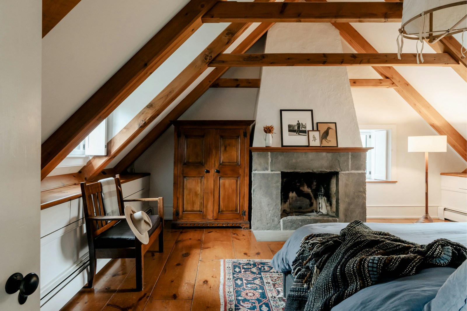 Chambre sous les combles avec lit installé sous la pente du toit.