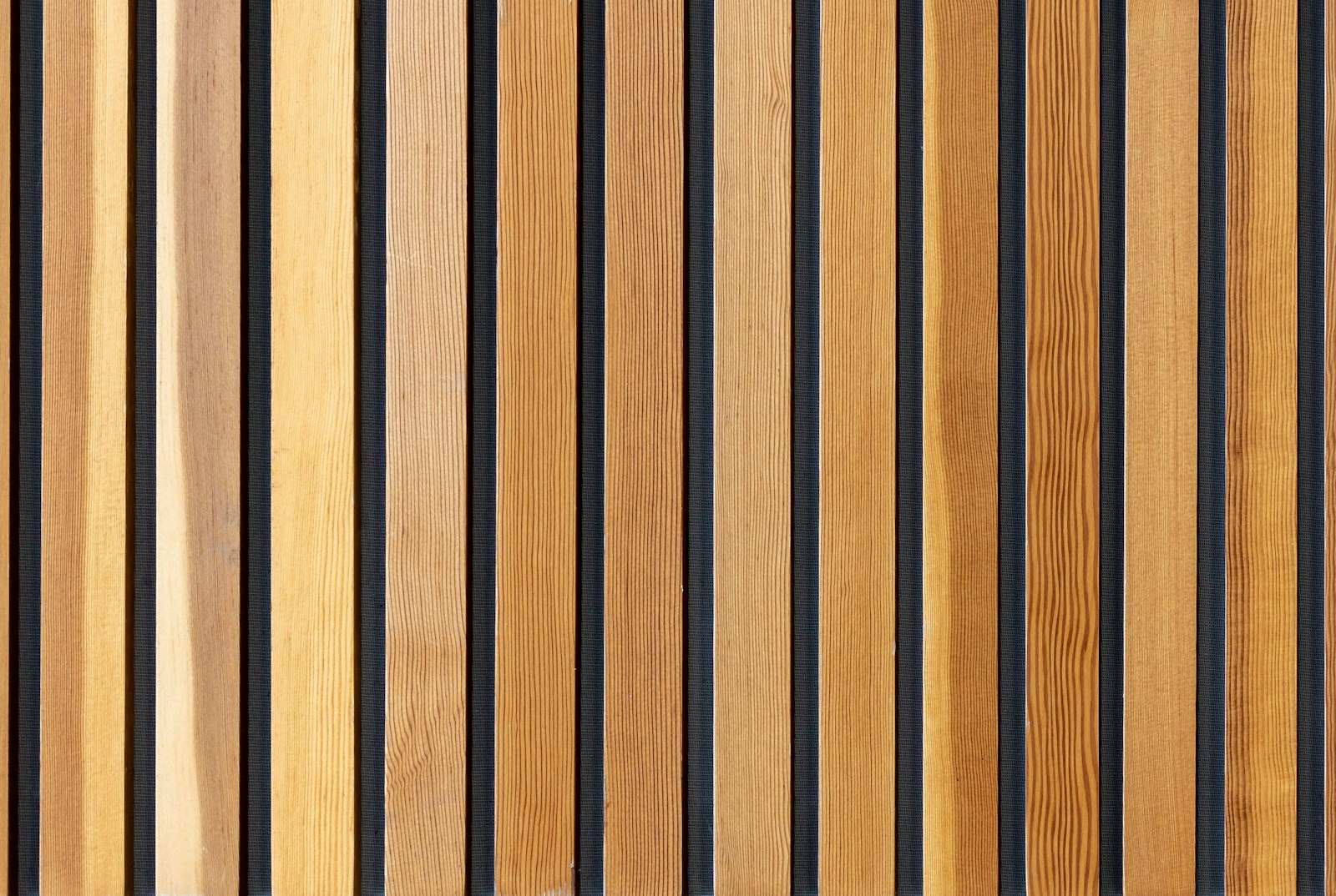 Claustra en tasseaux de bois clair filtrant la lumière