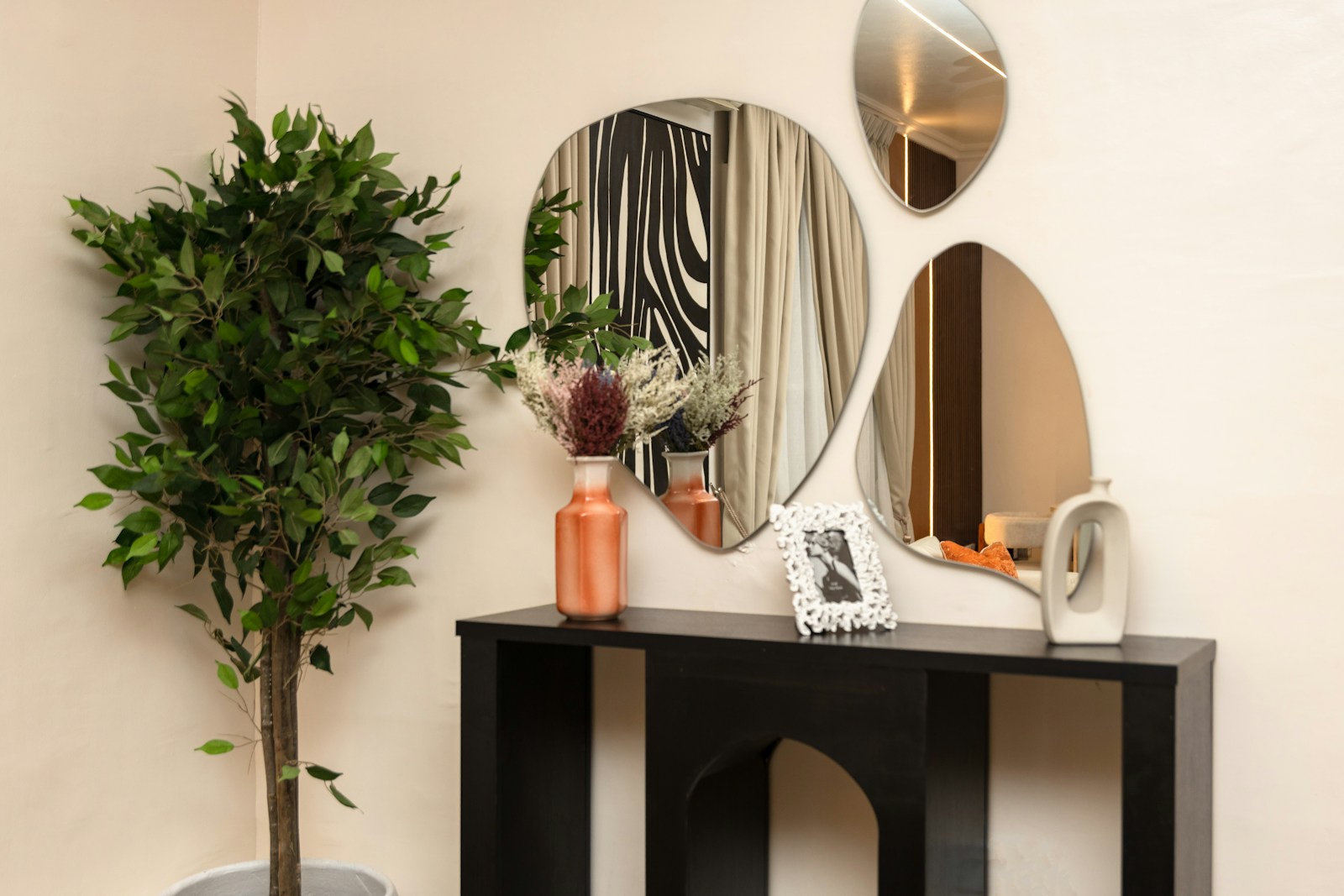 Entrée claire et dégagée avec console, miroir et plante verte.