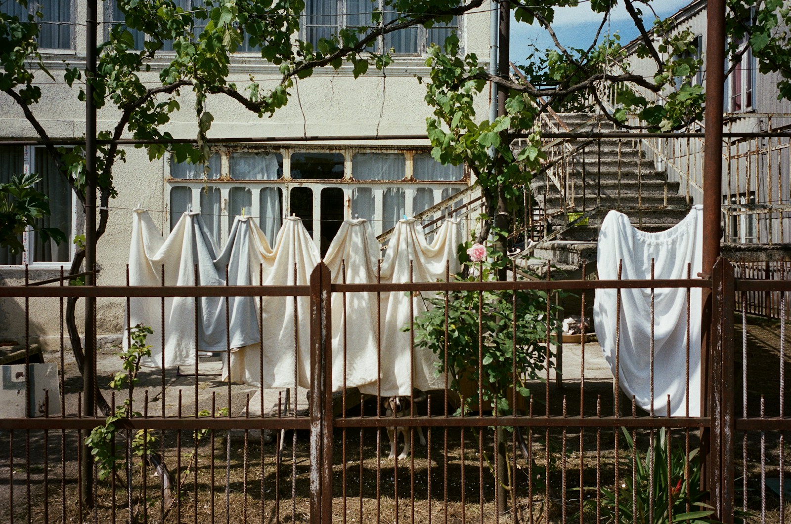 Étendoir à linge avec draps en lin près d'une fenêtre lumineuse.