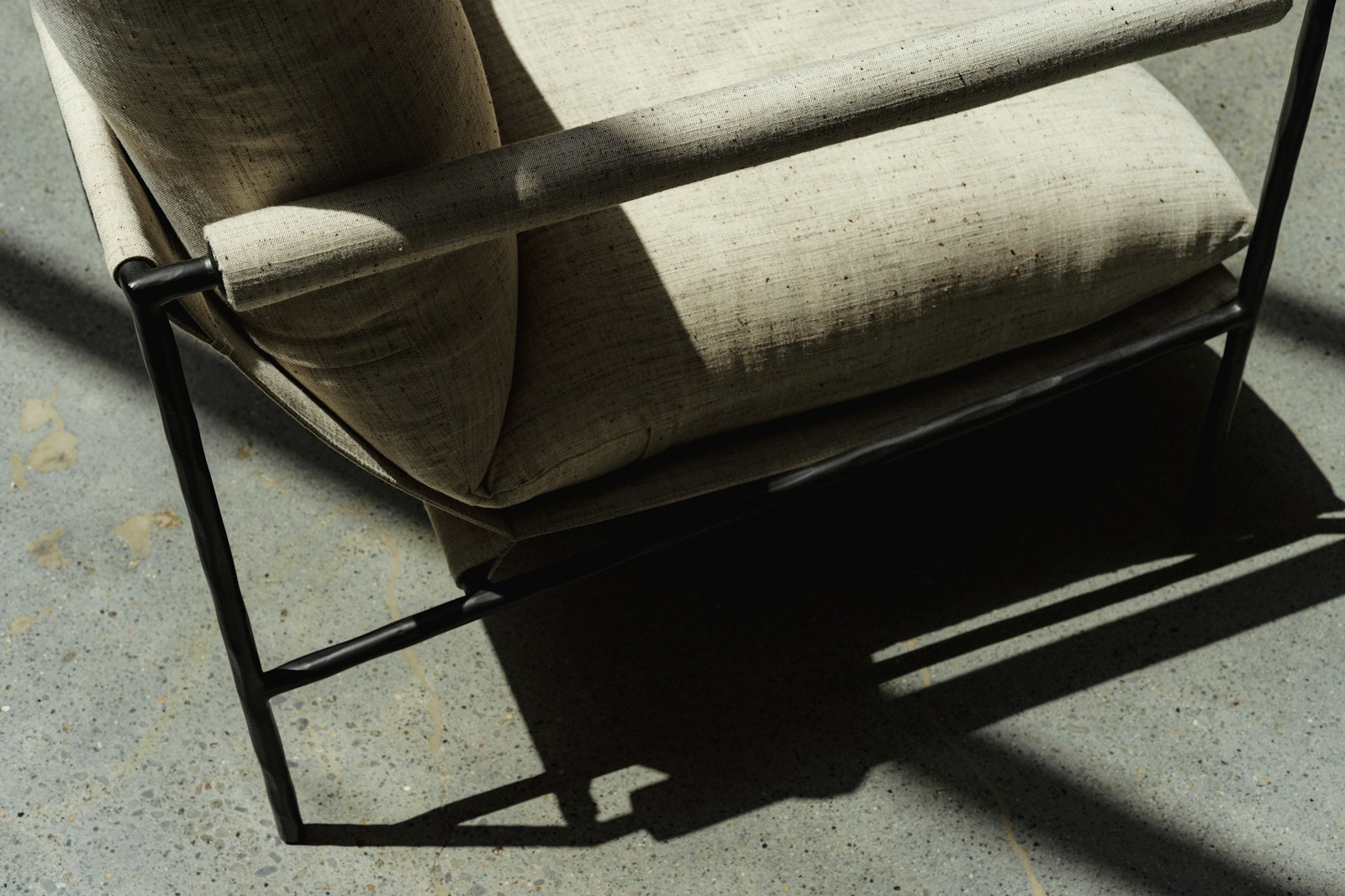 Fauteuil aux lignes droites et à l'assise profonde, garni de lin naturel.