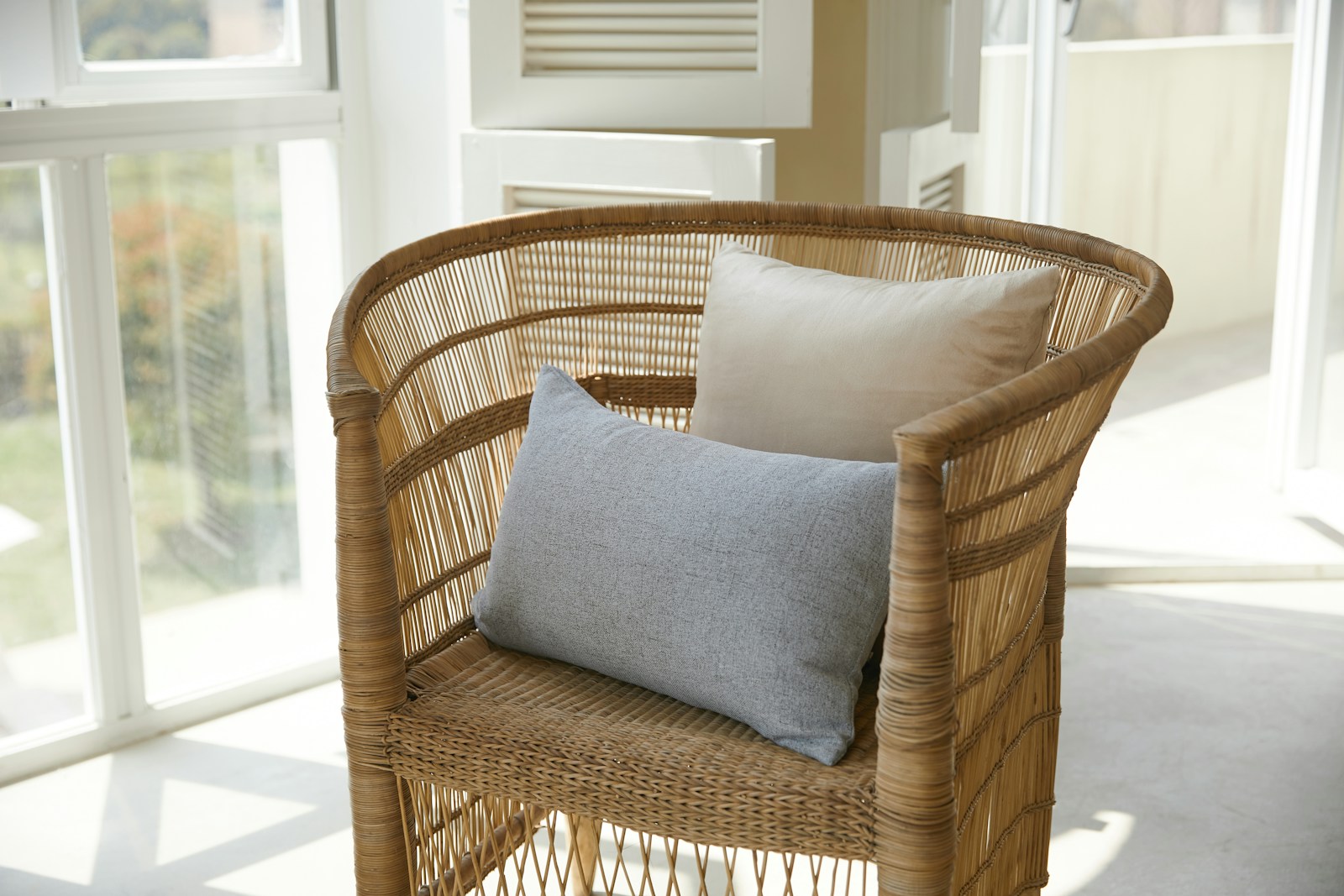 Fauteuil en rotin et coussins en lin dans un intérieur naturel et chaleureux
