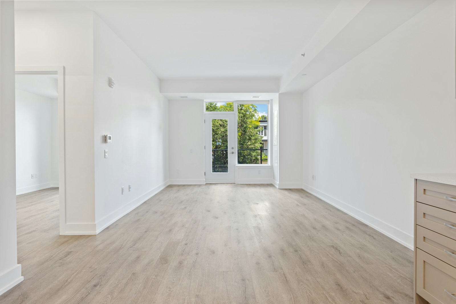Grand salon lumineux au parquet nu, avant aménagement