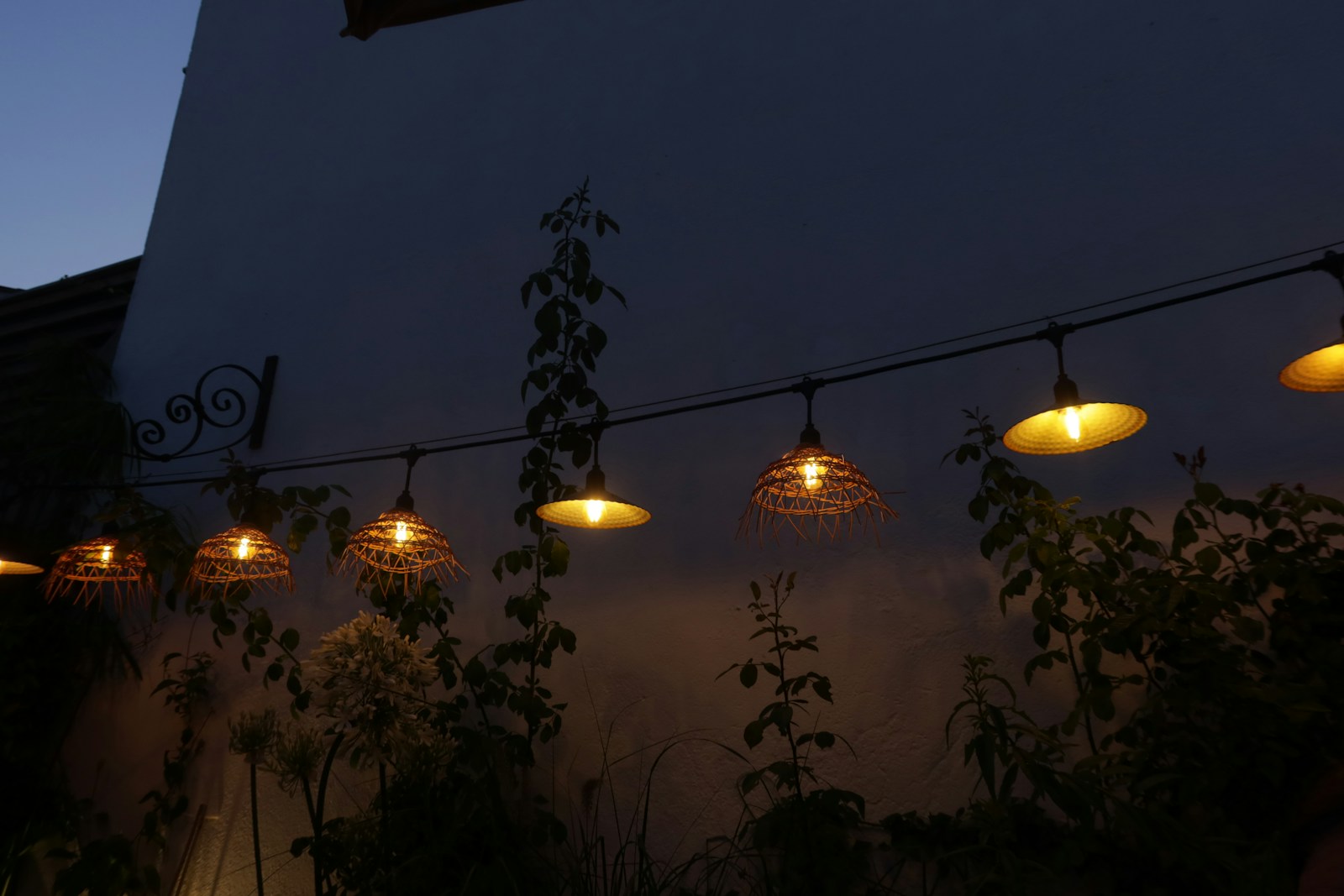 Guirlande lumineuse installée sur un mur extérieur à la tombée du soir.