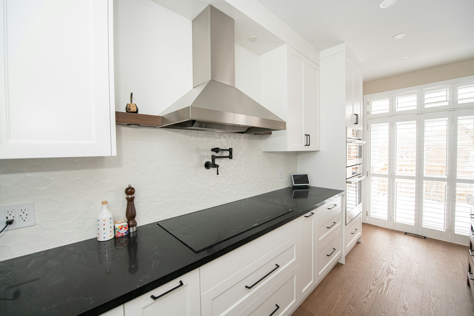 Hotte de cuisine installée au-dessus d'une plaque de cuisson dans un séjour ouvert.