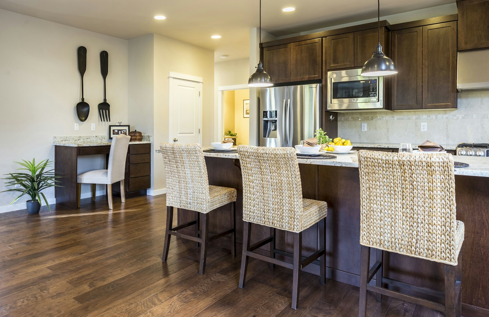 Îlot de cuisine avec bar et tabourets en bois séparant le salon