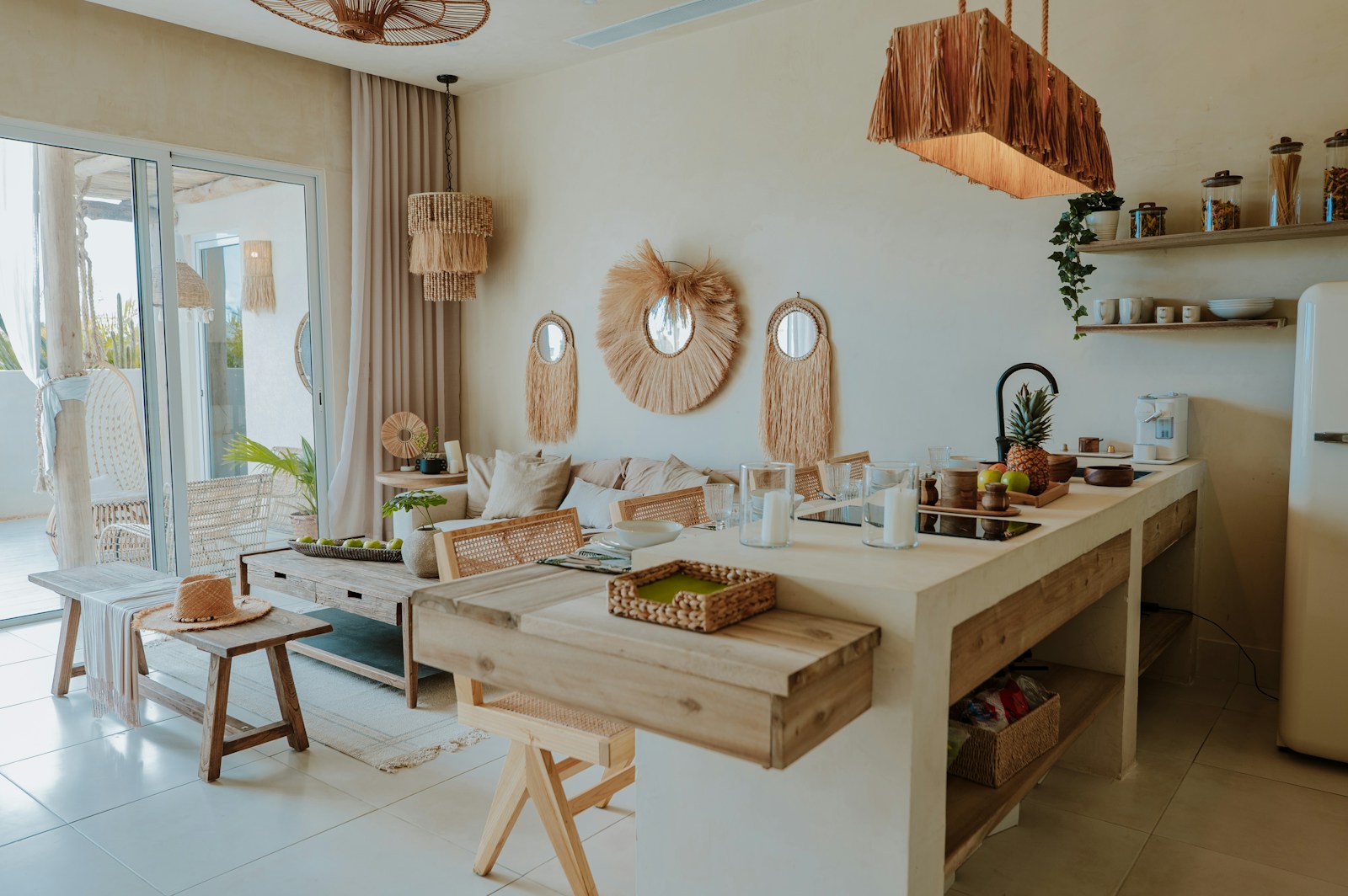 Îlot de cuisine avec tabourets de bar en rotin, ouvert sur le salon.