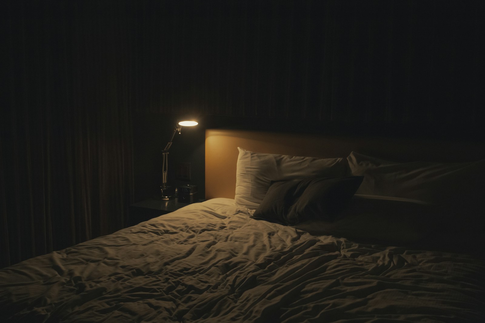 Lampe de chevet allumée diffusant une lumière chaude dans une chambre le soir