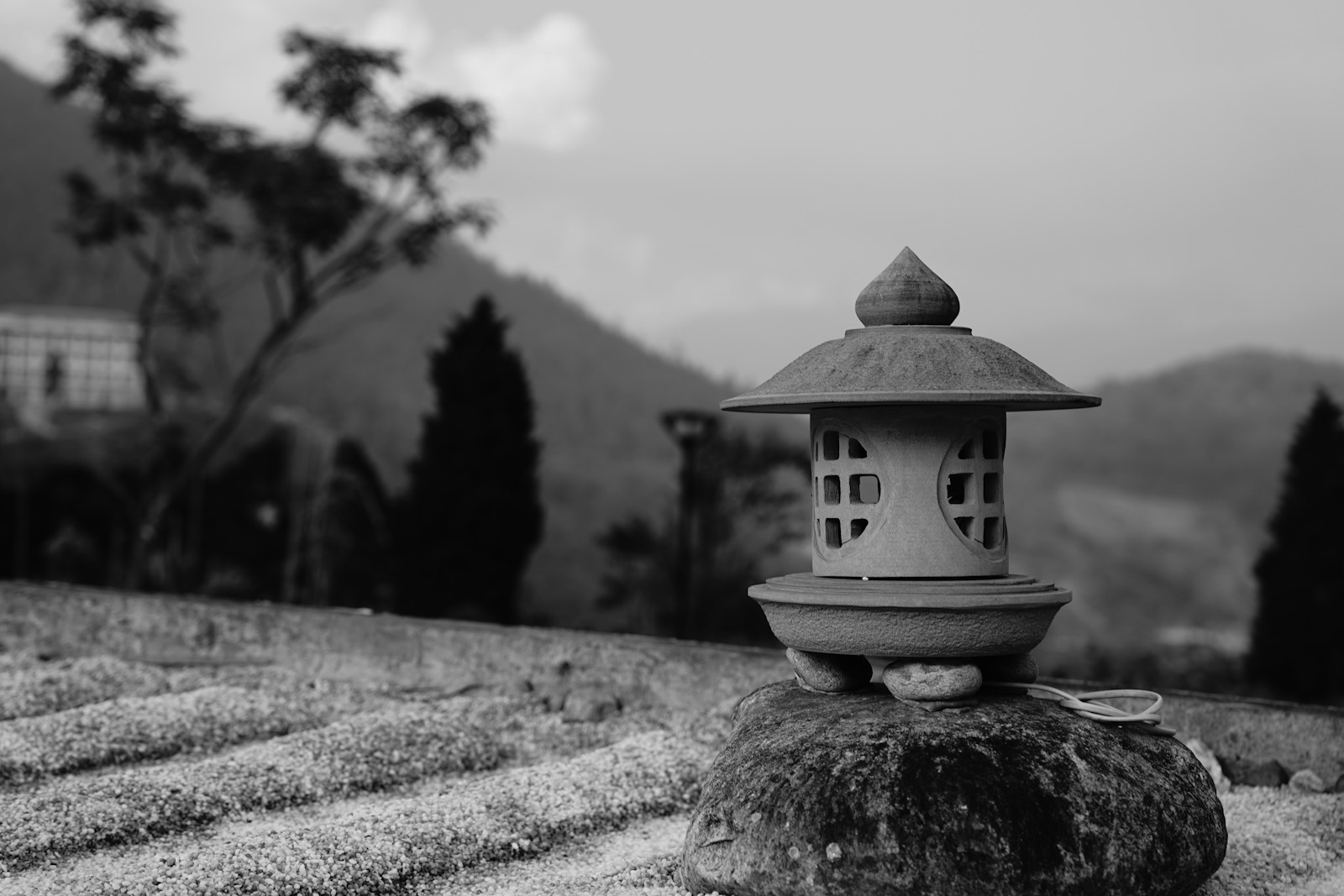 Lanternes à bougie en terre cuite posées sur un muret de pierre la nuit.