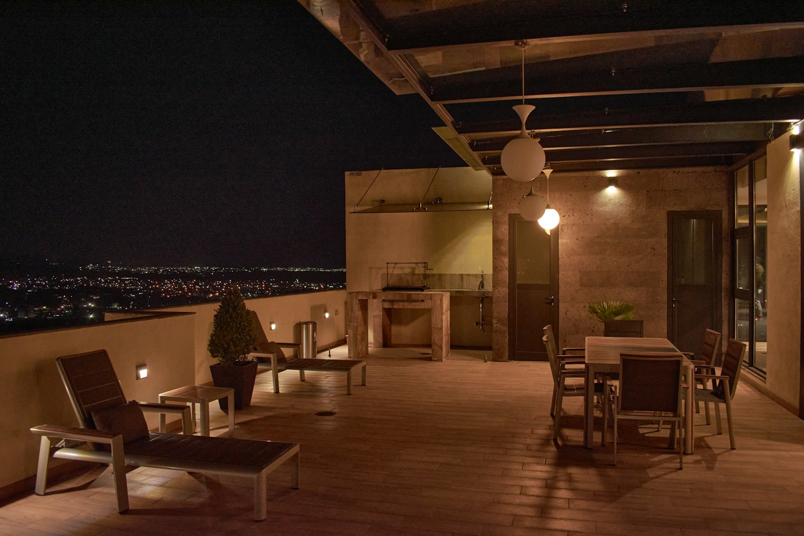 Lanternes et bougies allumées sur une terrasse à la tombée du soir.