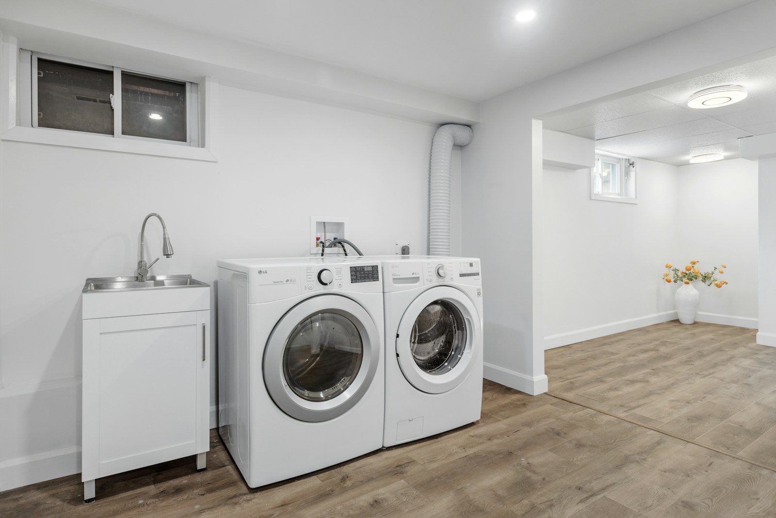 Lave-linge et sèche-linge côte à côte sous un plan de travail en bois continu.