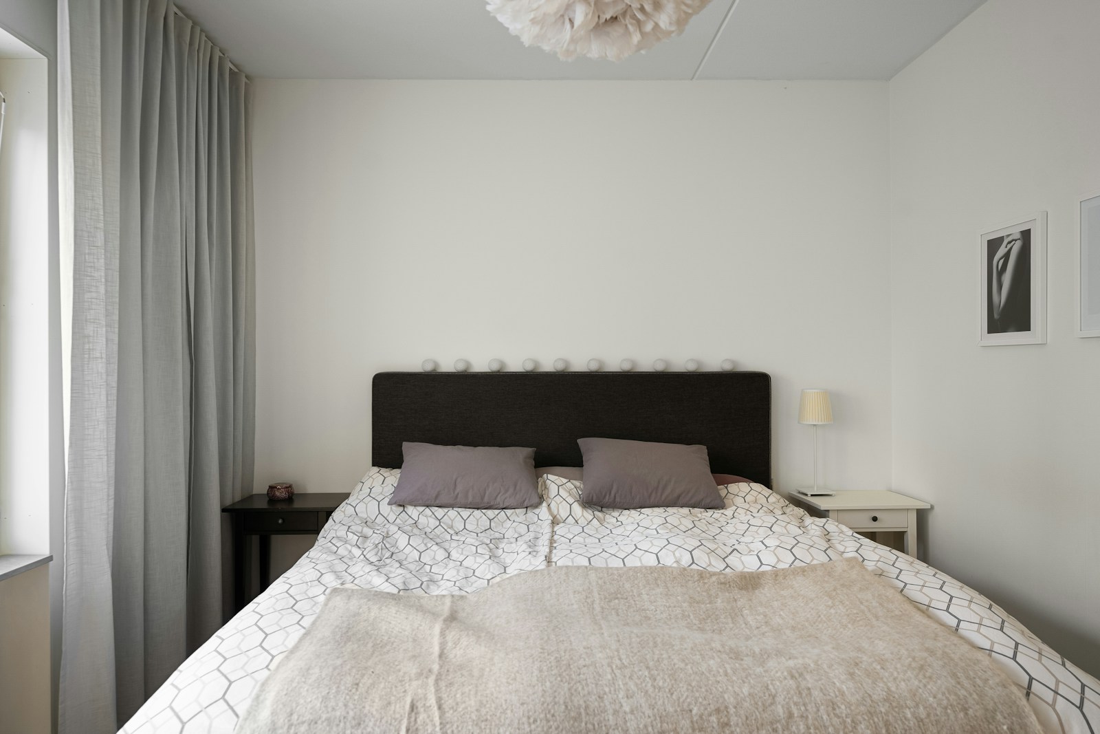 Lit double avec tête de lit contre un mur plein dans une petite chambre.