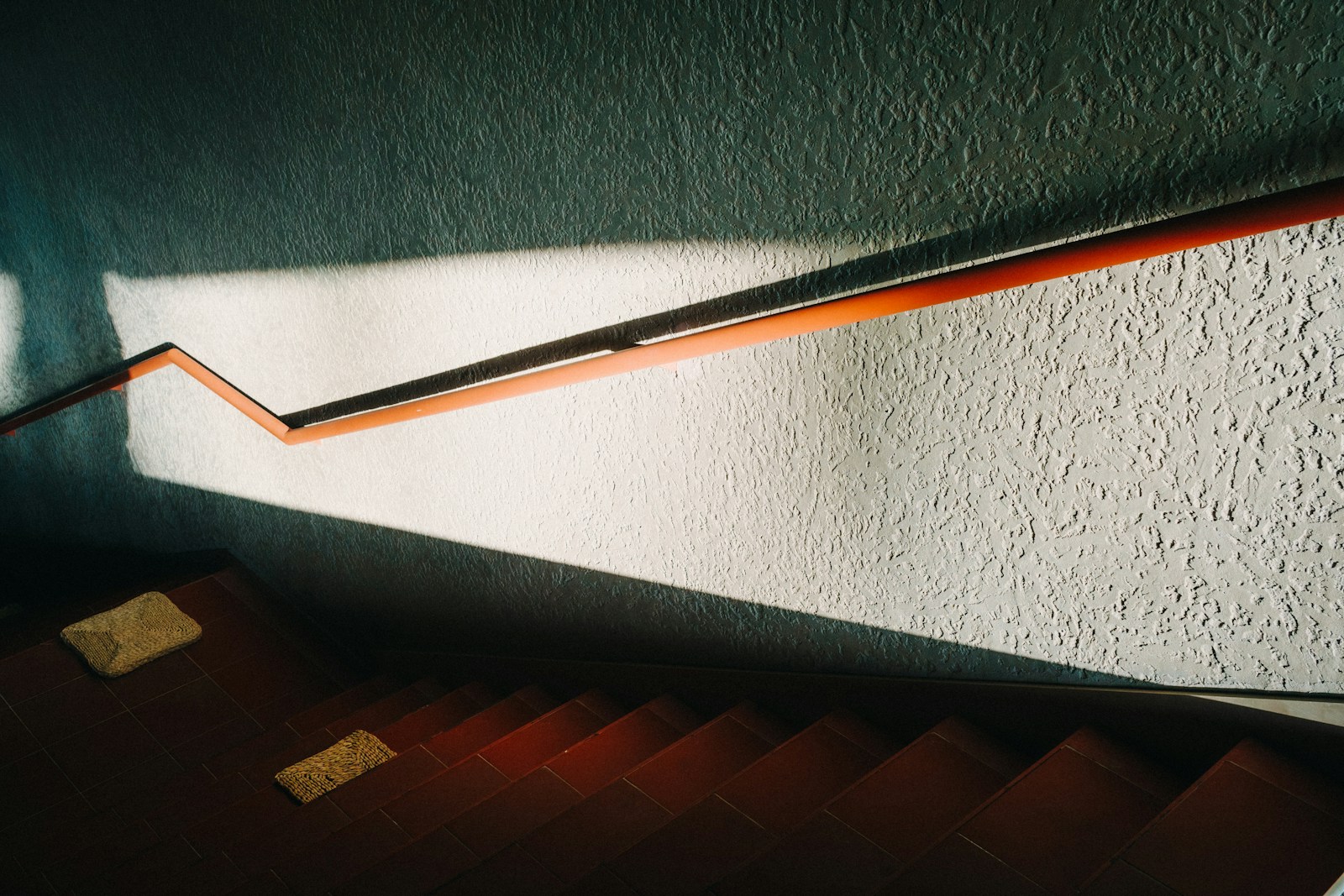 Miroir rond accroché sur le mur d'une montée d'escalier.