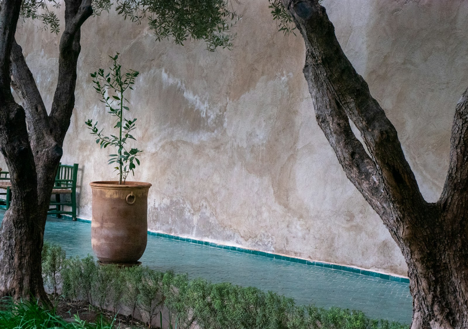 Mur extérieur en enduit à la chaux teinté ocre sous la lumière du sud.