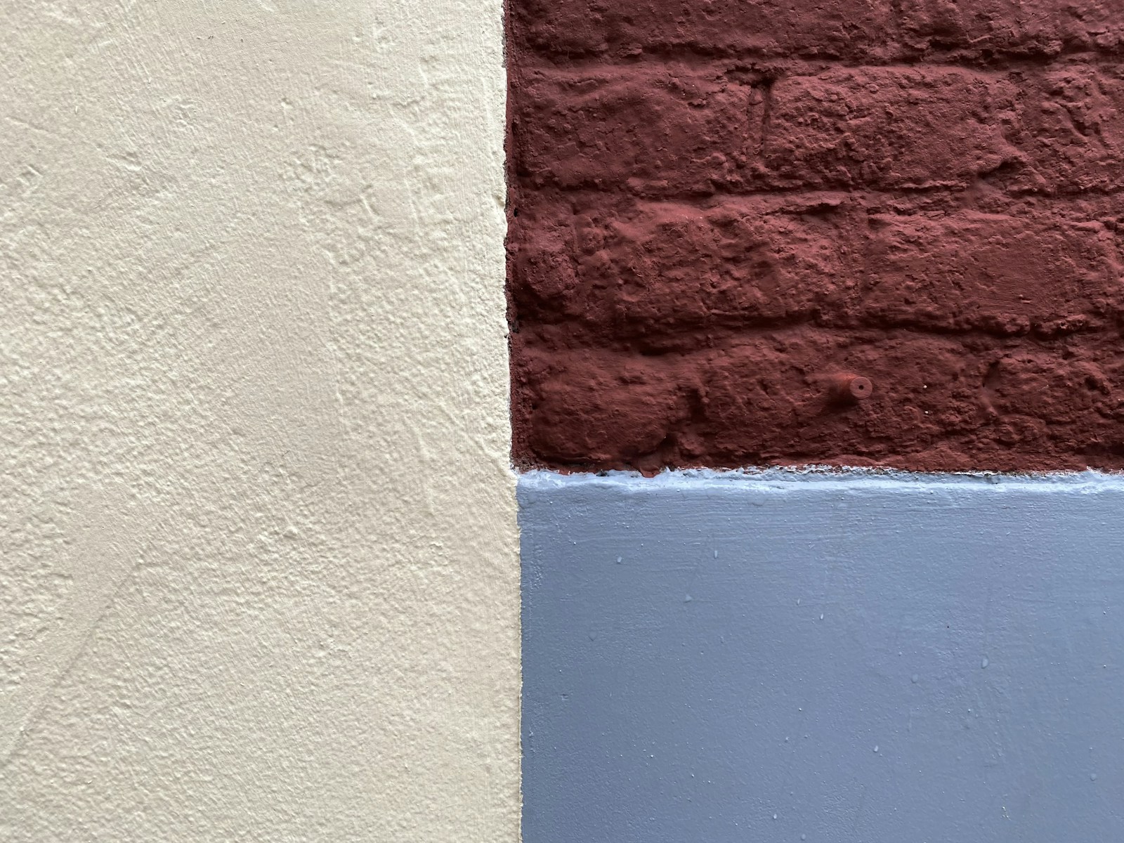 Nuances de blanc cassé, sable et bleu grisé posées côte à côte sur un mur.