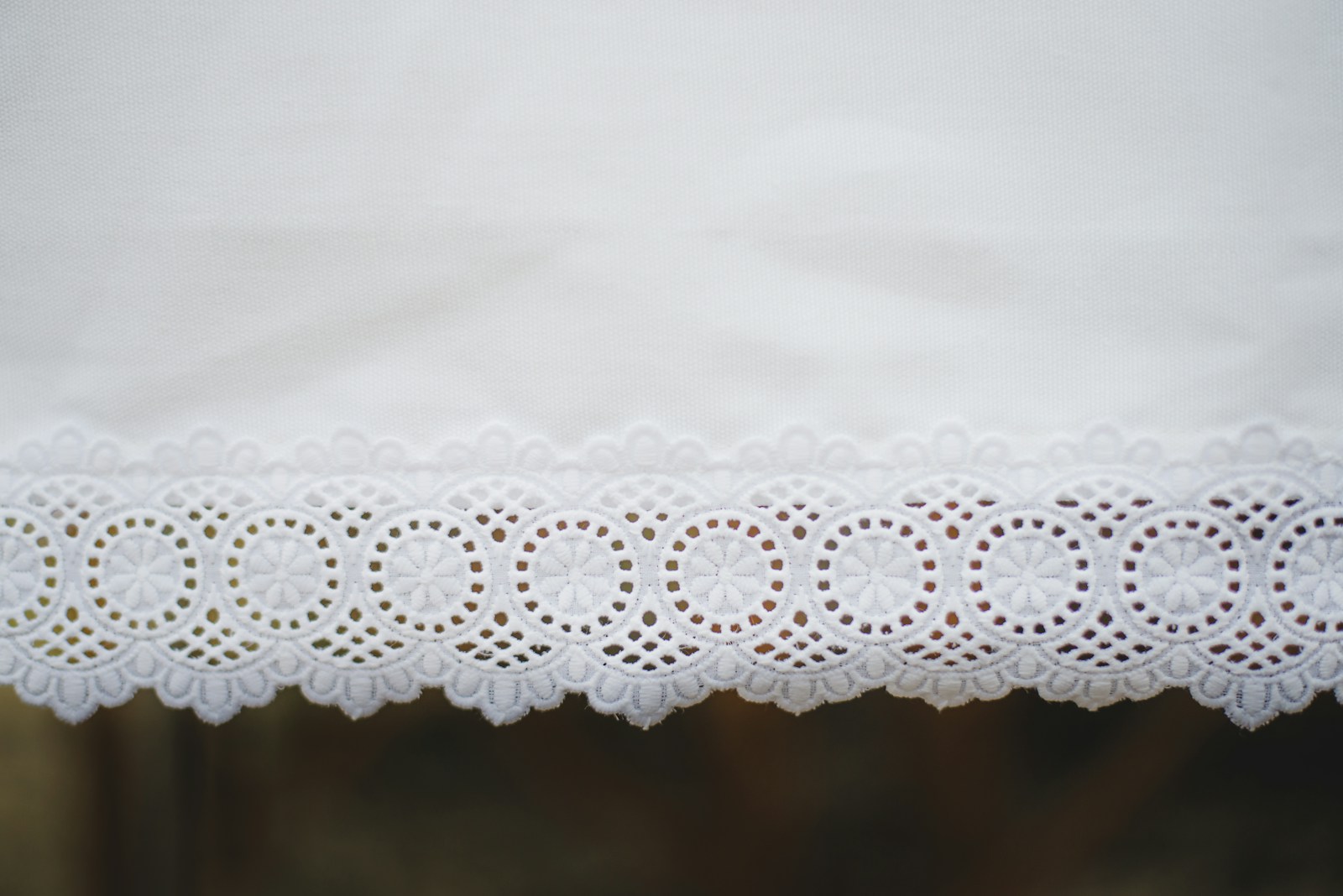 Parure de lit en coton blanc à broderie anglaise, vue rapprochée.