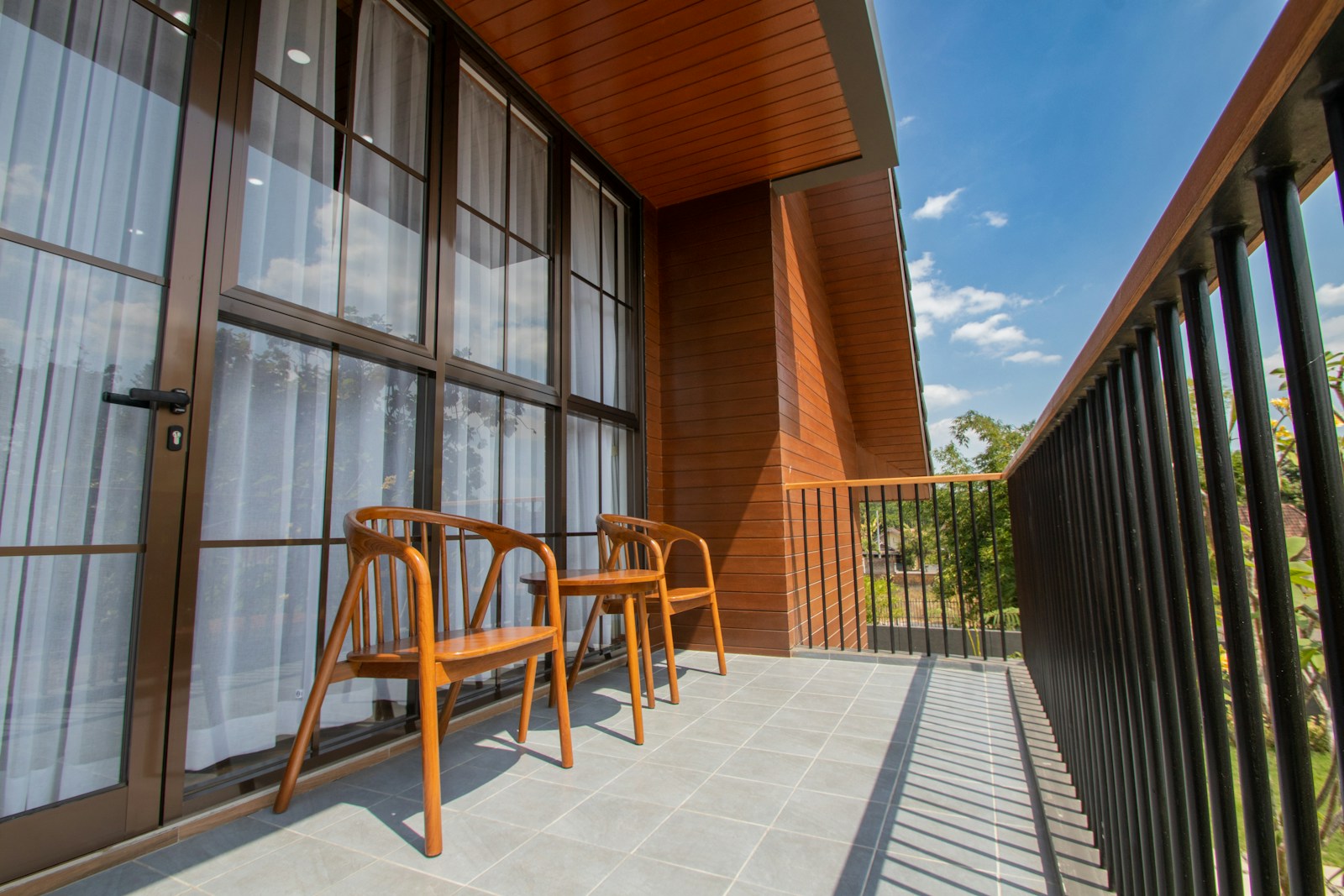 Petit balcon urbain étroit aménagé avec une table pliante et deux chaises.