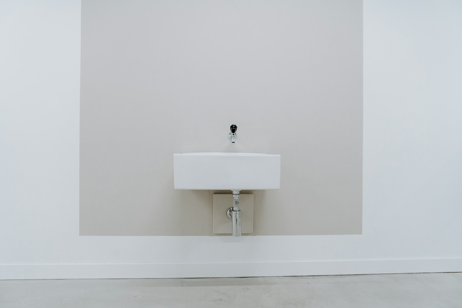 Petit lave-mains d'angle avec robinetterie en laiton dans des WC.
