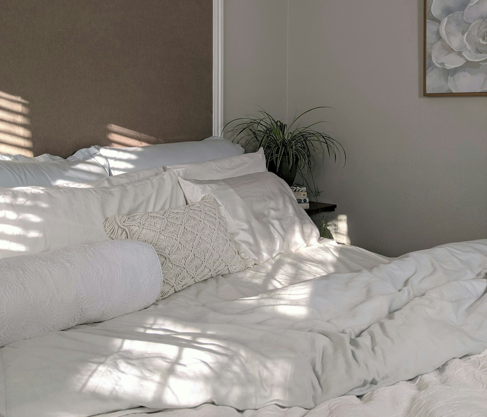 Petite chambre d'adulte aux murs beiges chauds avec linge de lit en lin et lumière douce
