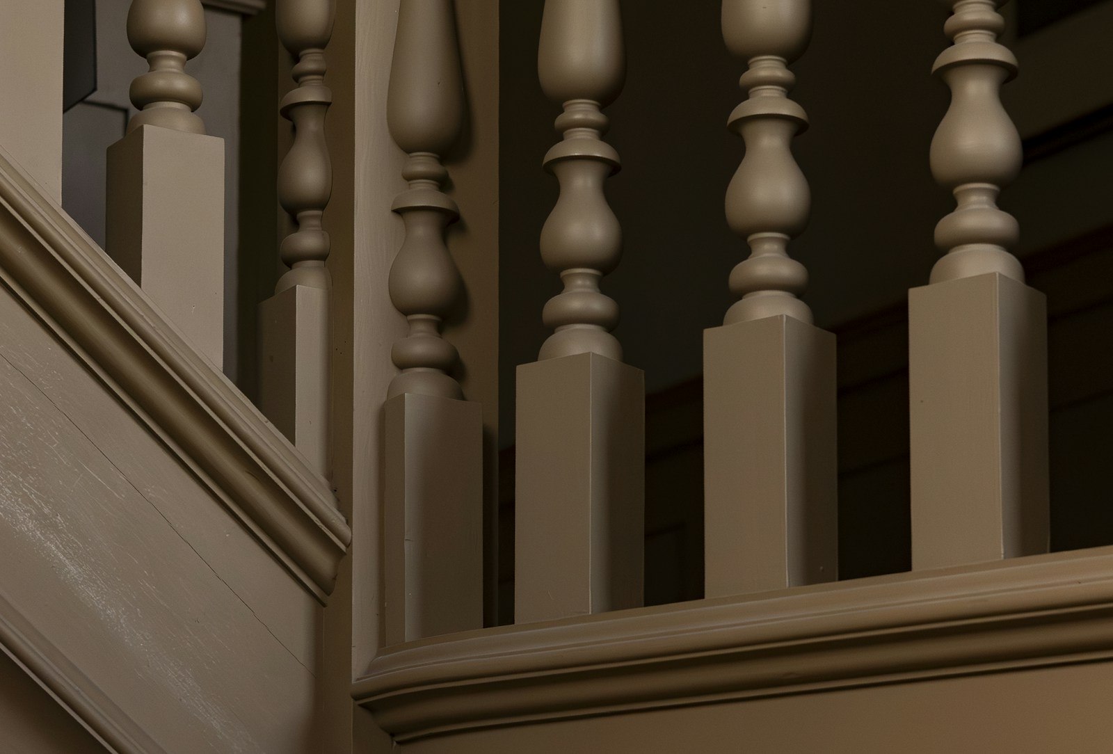 Rampe d'escalier en bois repeinte, balustres et main courante.