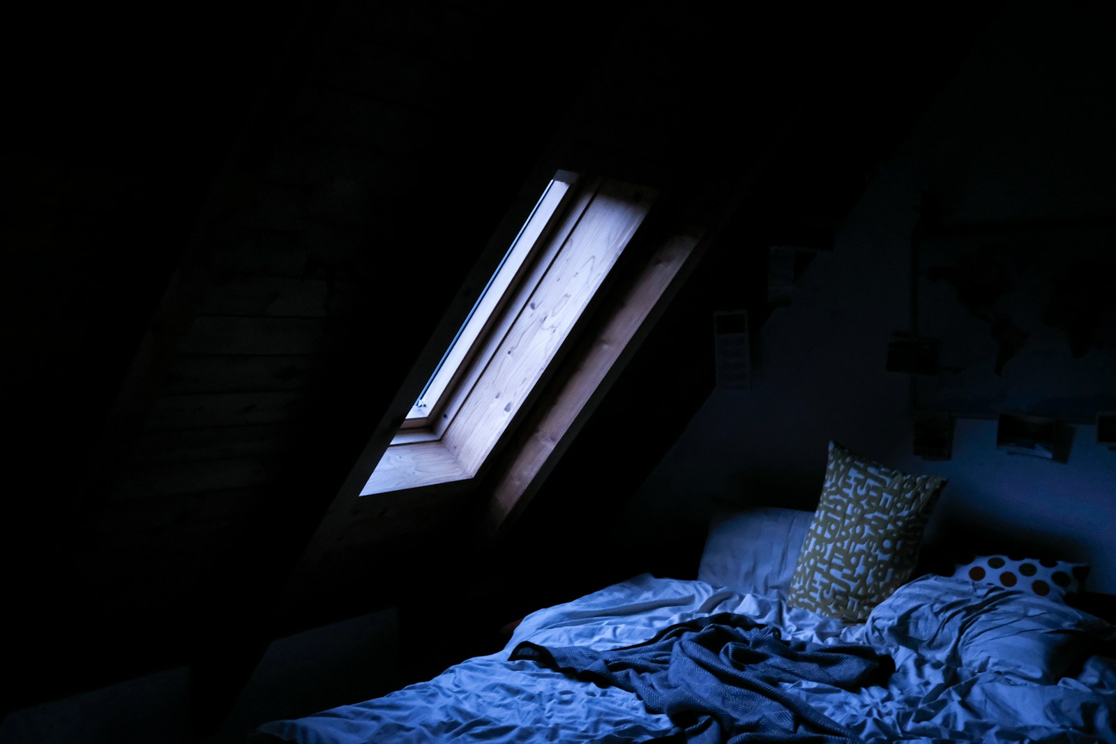 Rideaux de lin et fenêtre ouverte dans une chambre sous les combles en été.
