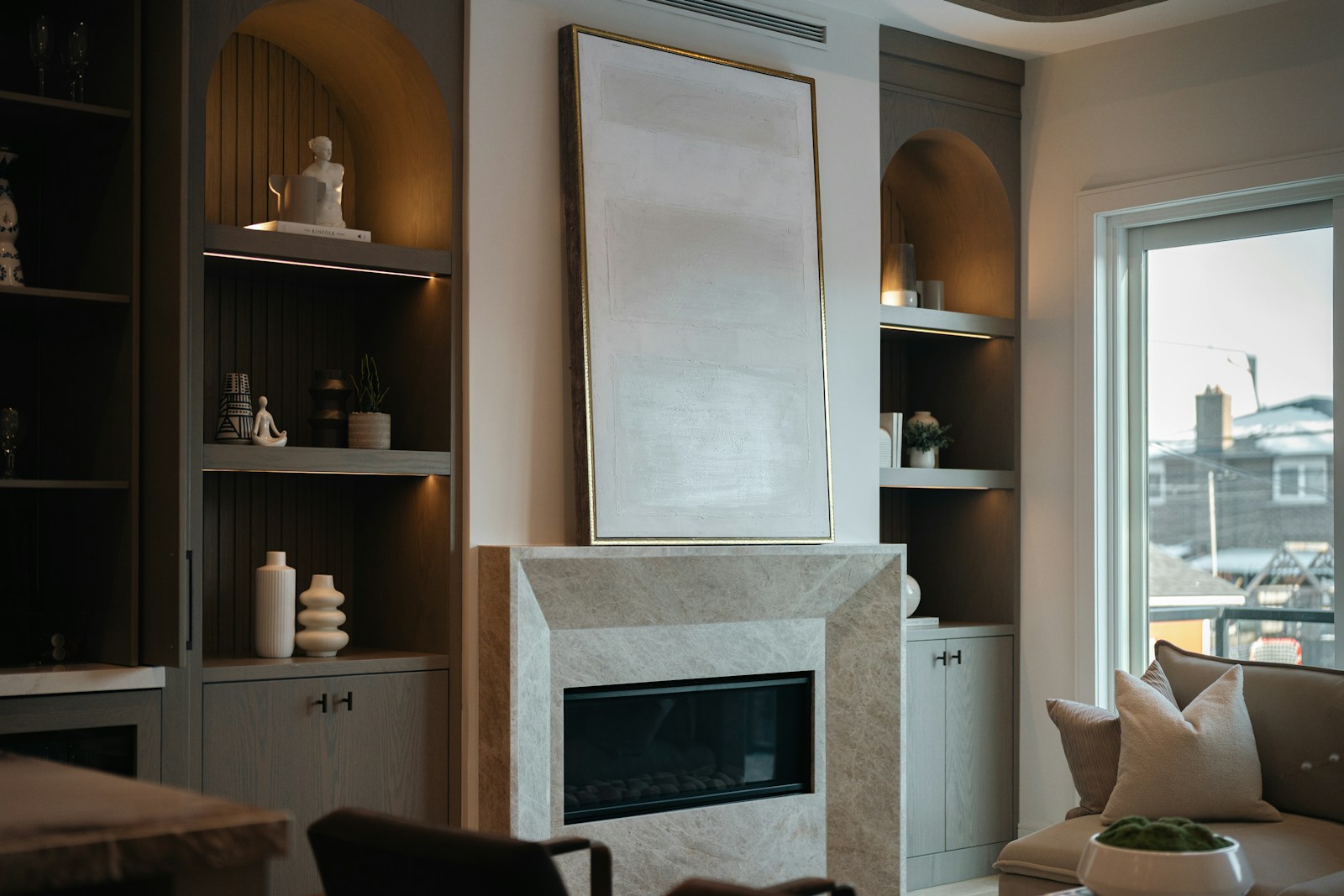 Salon chaleureux organisé autour d'une cheminée, avec deux fauteuils qui lui font face.
