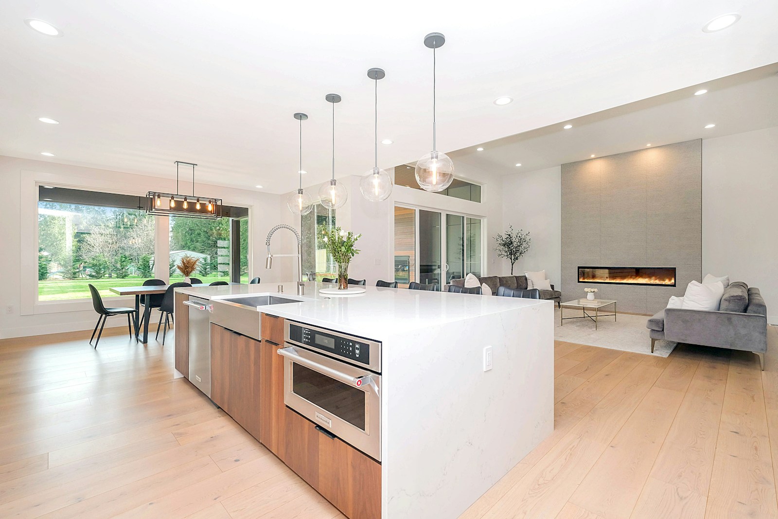 Séjour de 25 m² avec cuisine ouverte, parquet clair et grande fenêtre.
