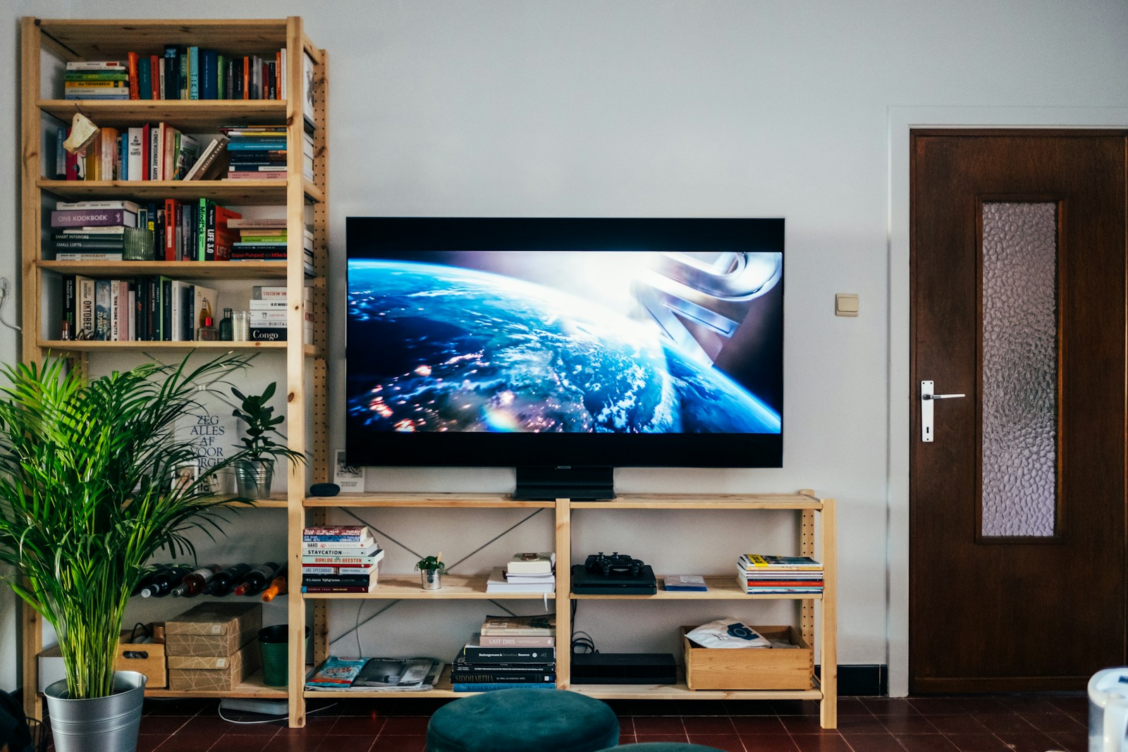 Télévision intégrée à un mur de tasseaux de bois avec tablette et éclairage doux.