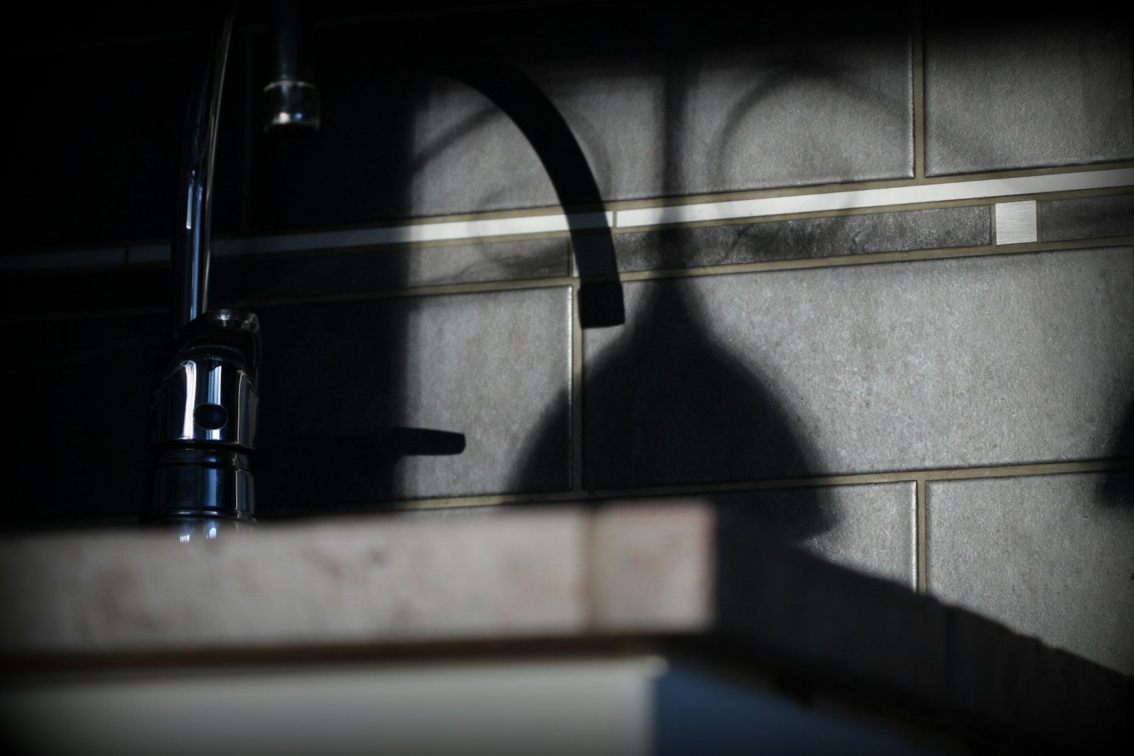 Traçage au niveau laser d'une ligne de pose sur le mur d'une cuisine